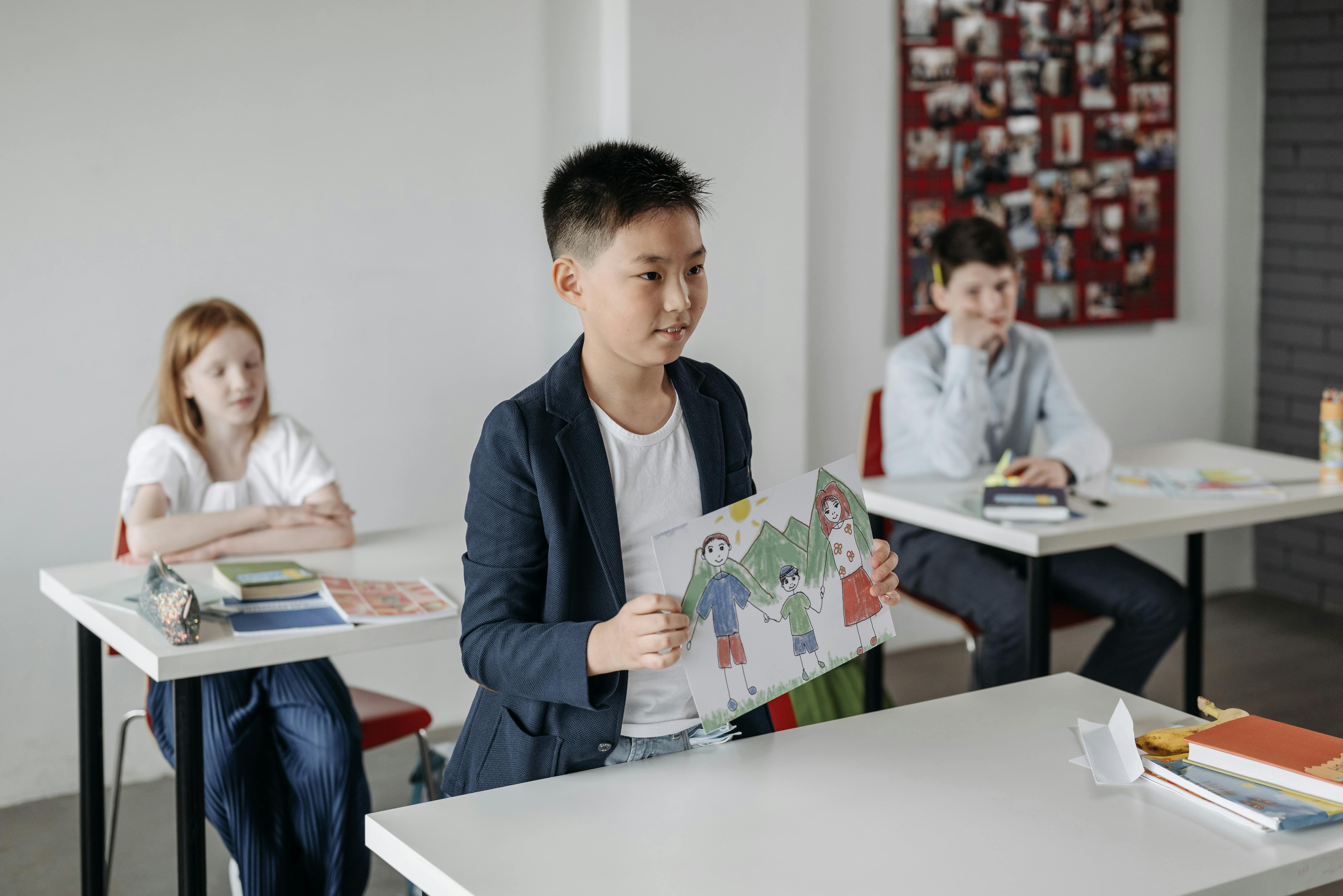 Child showing drawing in classroom during schools free breakfast clubs and morning enrichment activities